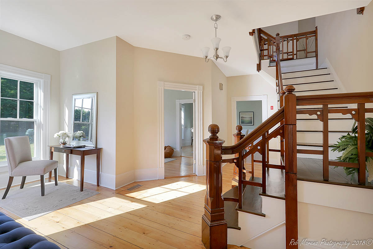 Restored staircase and wide-plank floors in a Boxford, MA renovation by Next Level Builders
